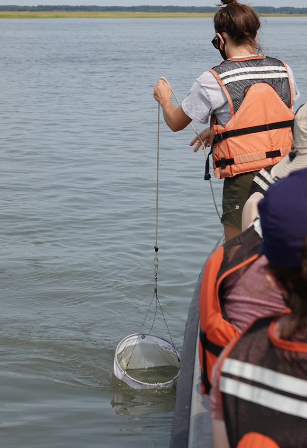 Student collecting samples on a body of water
