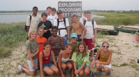 group of campers in front of water