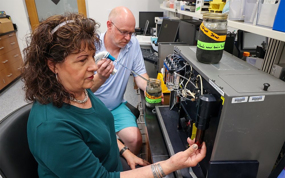 Batten School & VIMS scientists Mary Ann Vogelbein (front) and Hamish Small (back) conduct “forever chemical” research using a biosensor tool. Photo by John Wallace.
