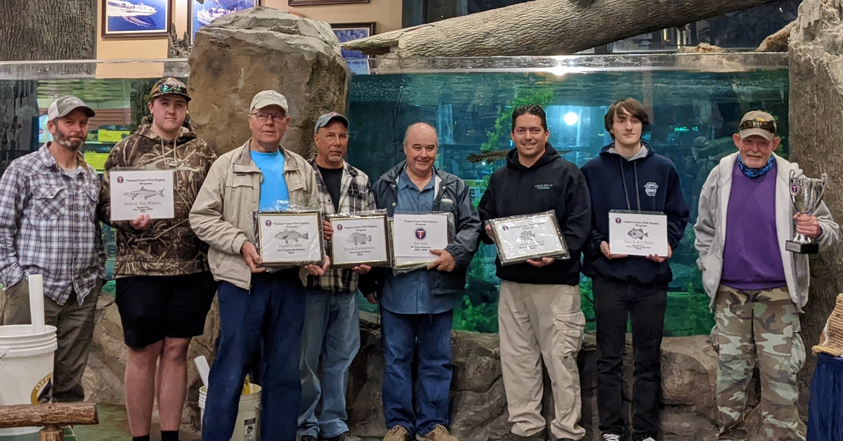 Susanna Music stands with seven individuals who received top tagger awards in 2023 for the Virginia Game Fish Tagging Program. 