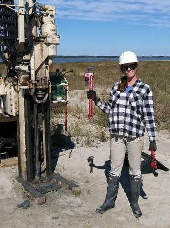 Photo of Jenn Connell standing next to drilling equipment
