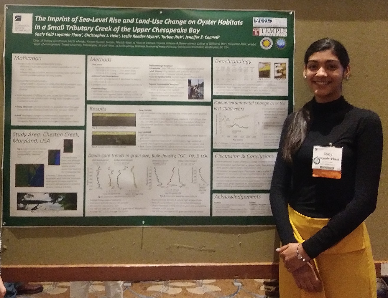 Soely Luyando-Flusa smiles in front of research presentation poster at conference