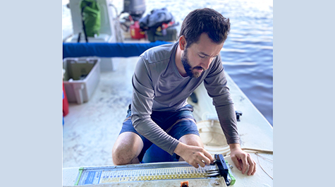 Scientist Jack Buchanan measures juvenile Striped Bass from the Pamunkey River
