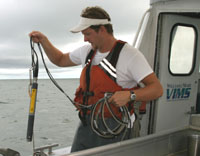 A scientist deploys a YSI to collect hydrographic data.