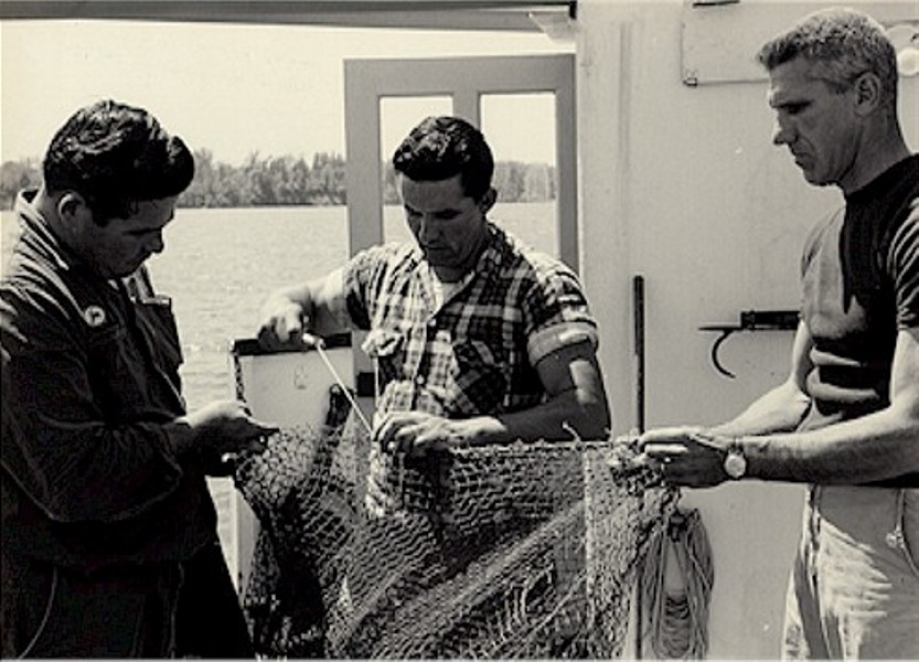 Scientists mending a trawl net while on deck